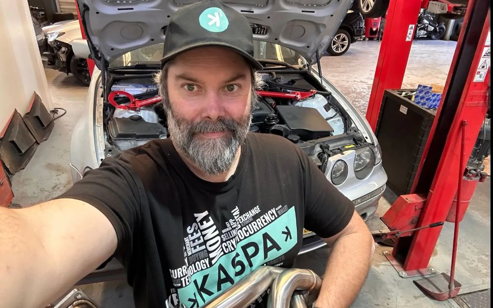 Bonnet up on the BMW showing the engine bay with a red strut brace fitted across it