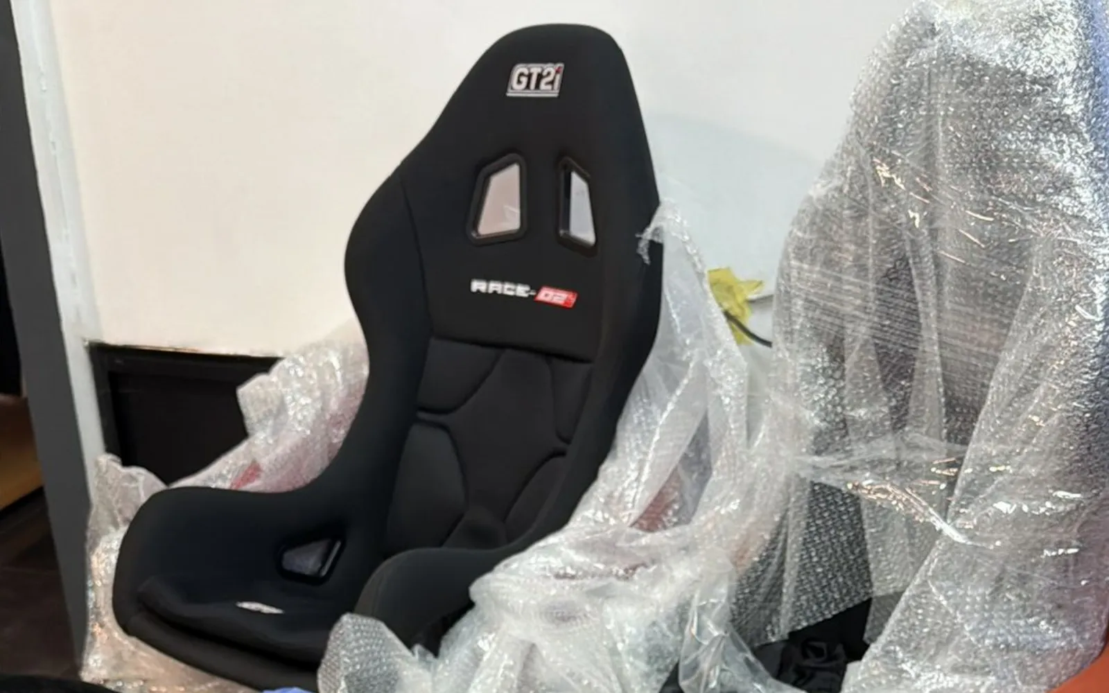 A new GT2i RACE-02 bucket seat unwrapped from its bubble packaging